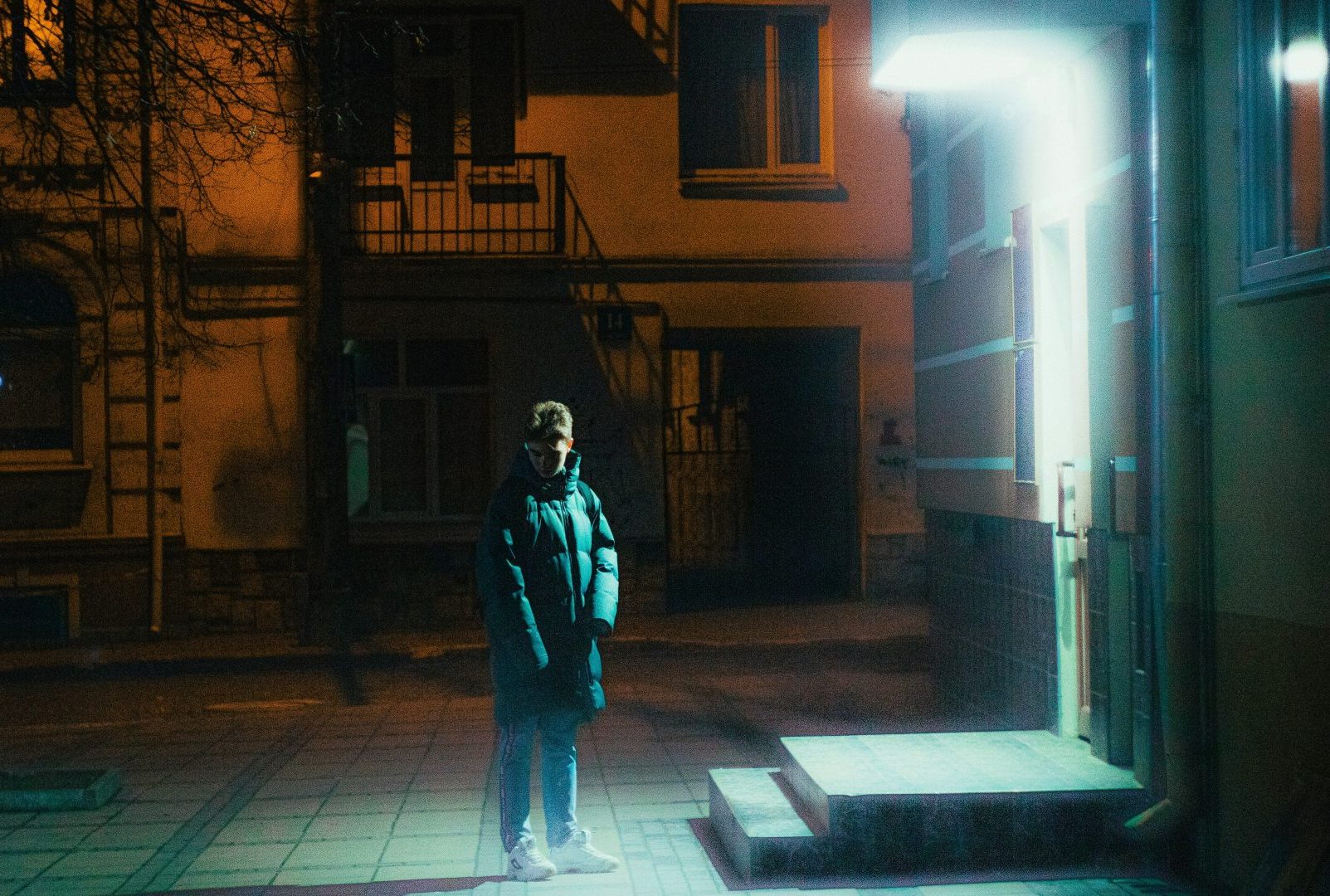 a man standing in front of a building at night